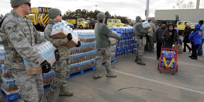 IDSS_NOAA men in uniforms help bring water to people in need.