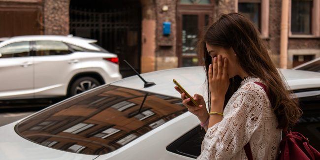 Quick-response-survey woman looking at her phone on street
