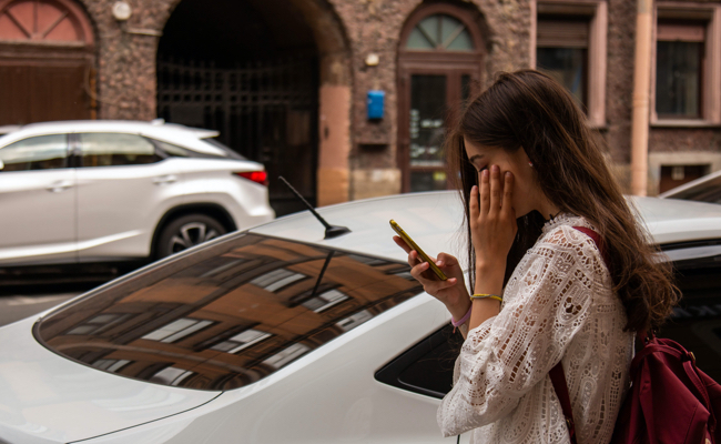 woman looking at her phone on street