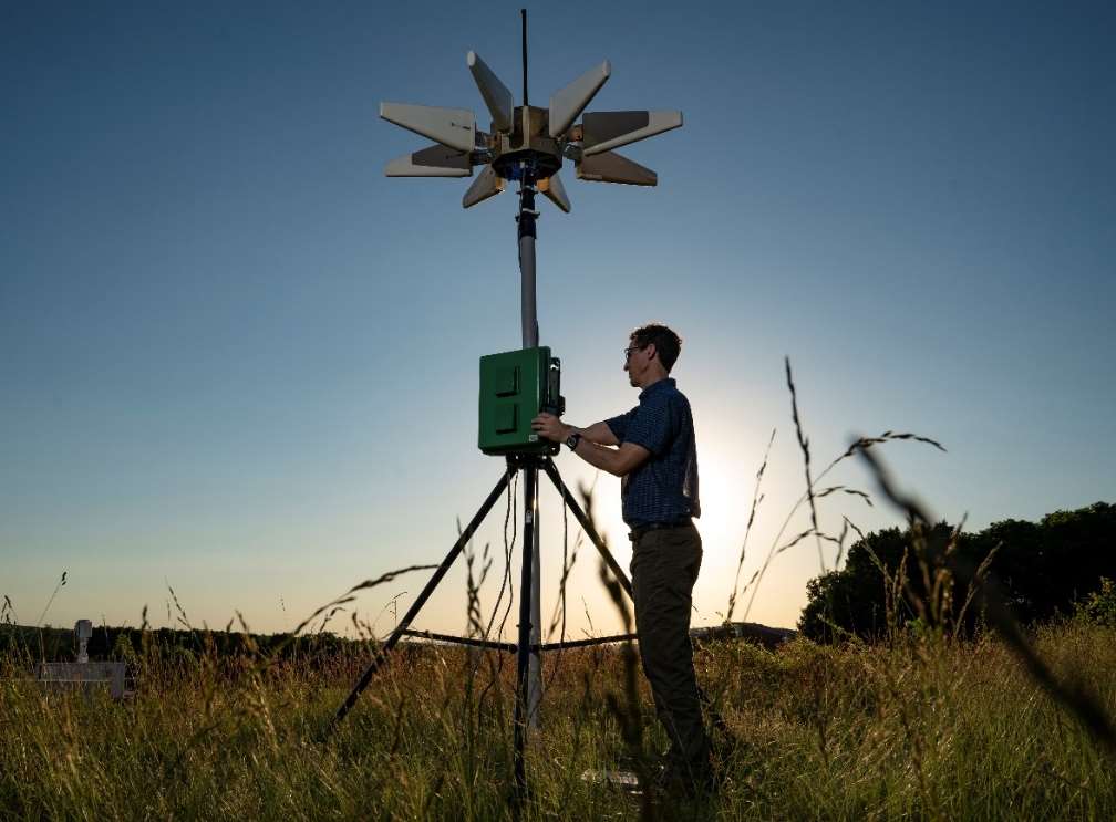 Man testing equipment in field to collect weather data